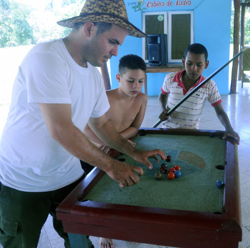 Yosel guía a los jóvenes en el mini billar, también creado por ellos mismos y de gran aceptación en los campistas. Foto: Orlando Durán Hernández/Adelante 