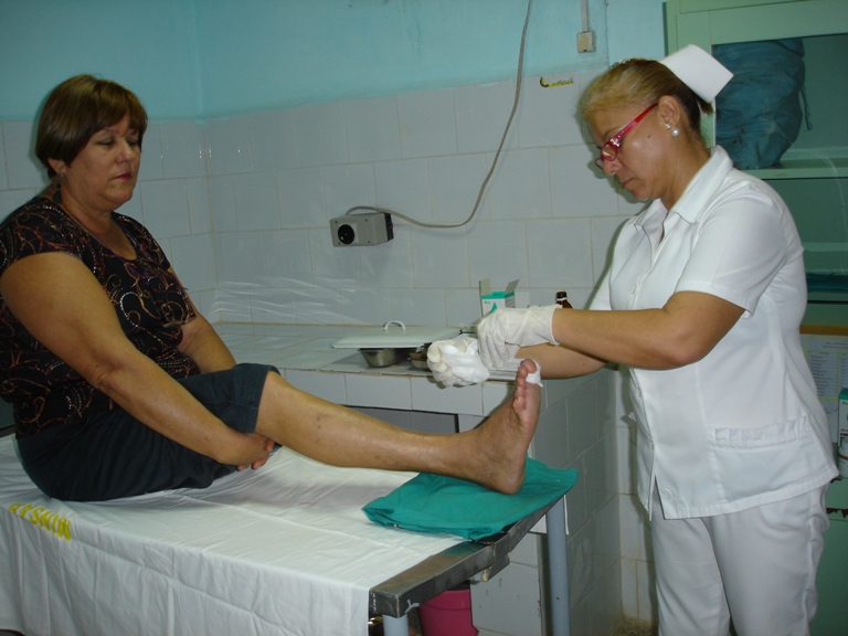 La licenciada Jacqueline aplica el medicamento a Consuelo, sentada porque así lo precisa el nivel de su lesión. Fotos: De la autora