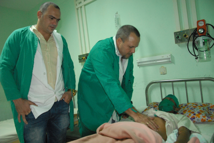 De izquierda a derecha, los doctores Estopiñán y Ruiz de Villa, pasan visita al niño.