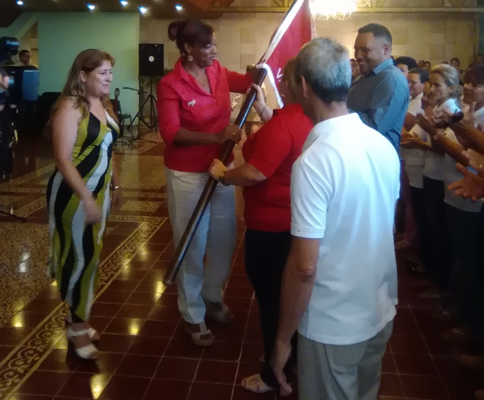 Representantes del colectivo de Copextel reciben la bandera de Vanguardia Nacional. Foto: De la autora Condecoran a colectivos de las comunicaciones