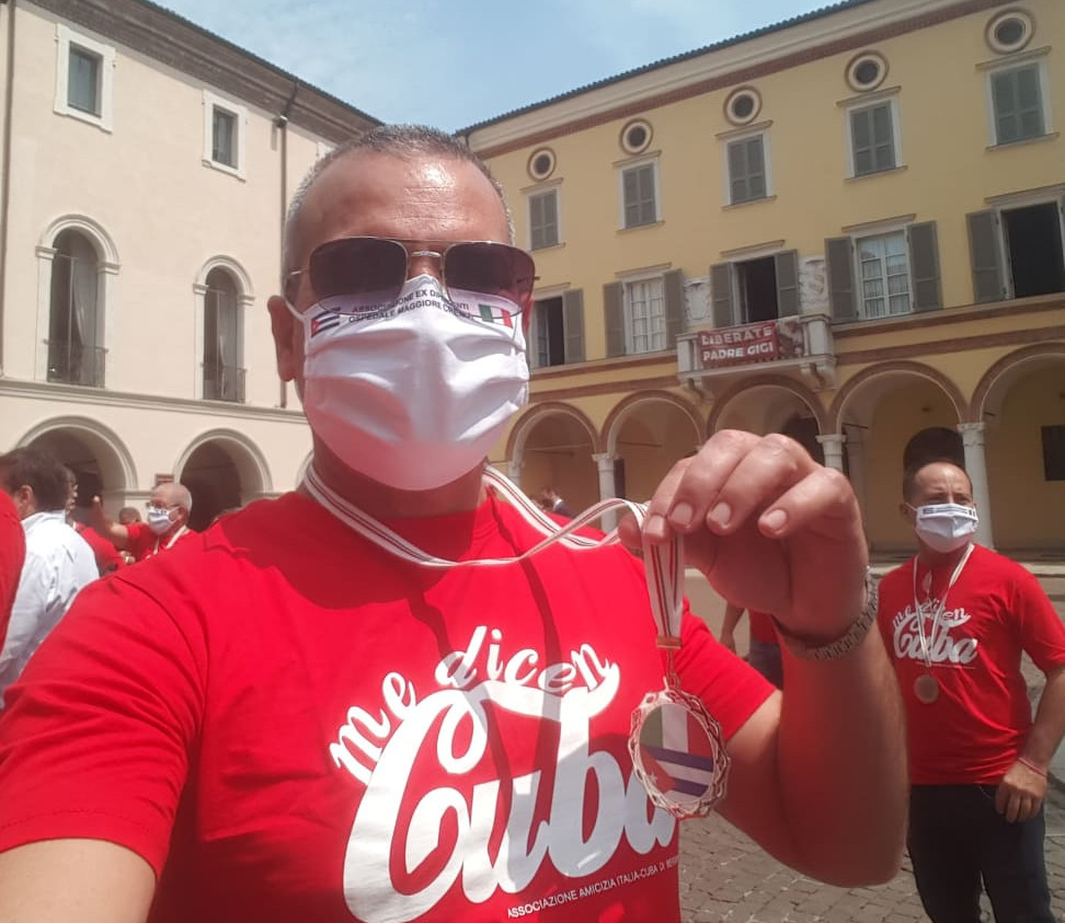 Con la medalla recibida por todos, que lleva las banderas de Italia y Cuba.
