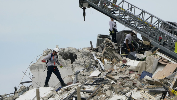 Un rescatista entre los escombros donde se derrumbó un ala de un edificio de viviendas de 12 pisos. Fotos: Tomadas de rt.com Declara Biden emergencia tras colapso de edificio en Miami