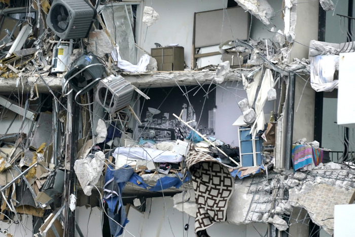 Artículos del hogar y escombros dentro del condominio de varios pisos derrumbado.